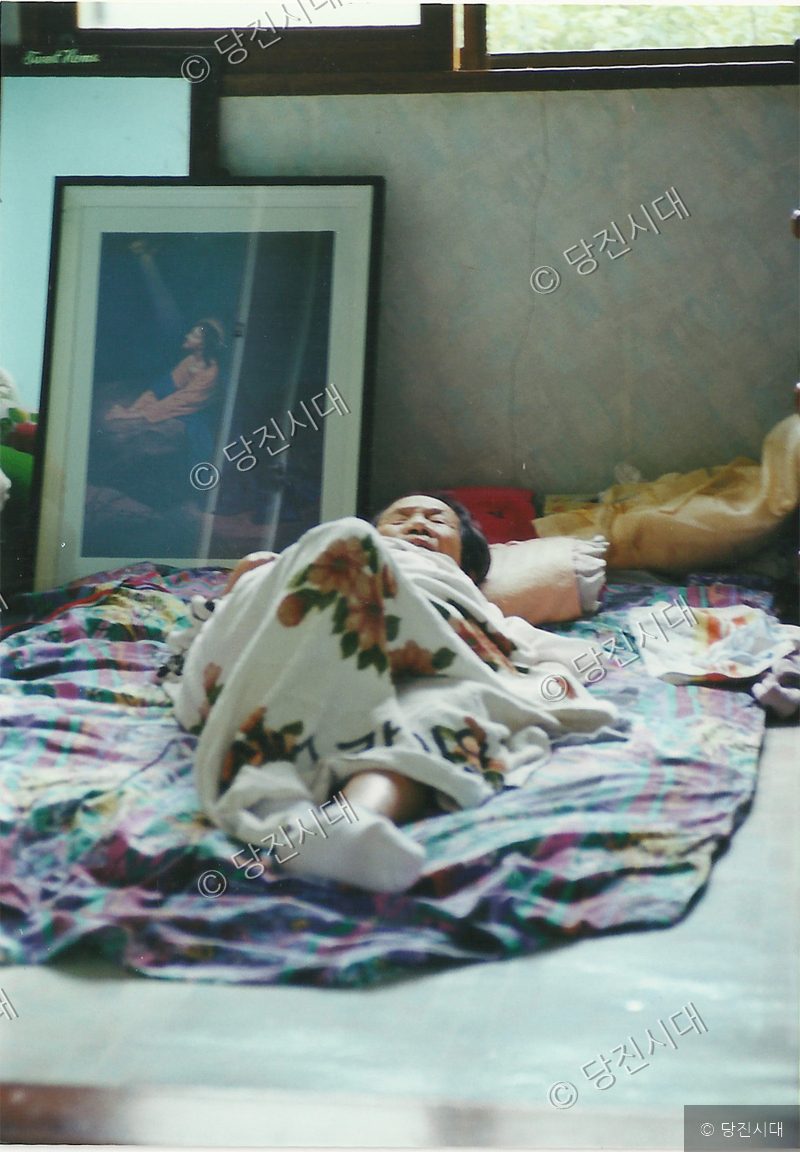 한 사람이 이불을 덮은 채 방에 누워 있다.