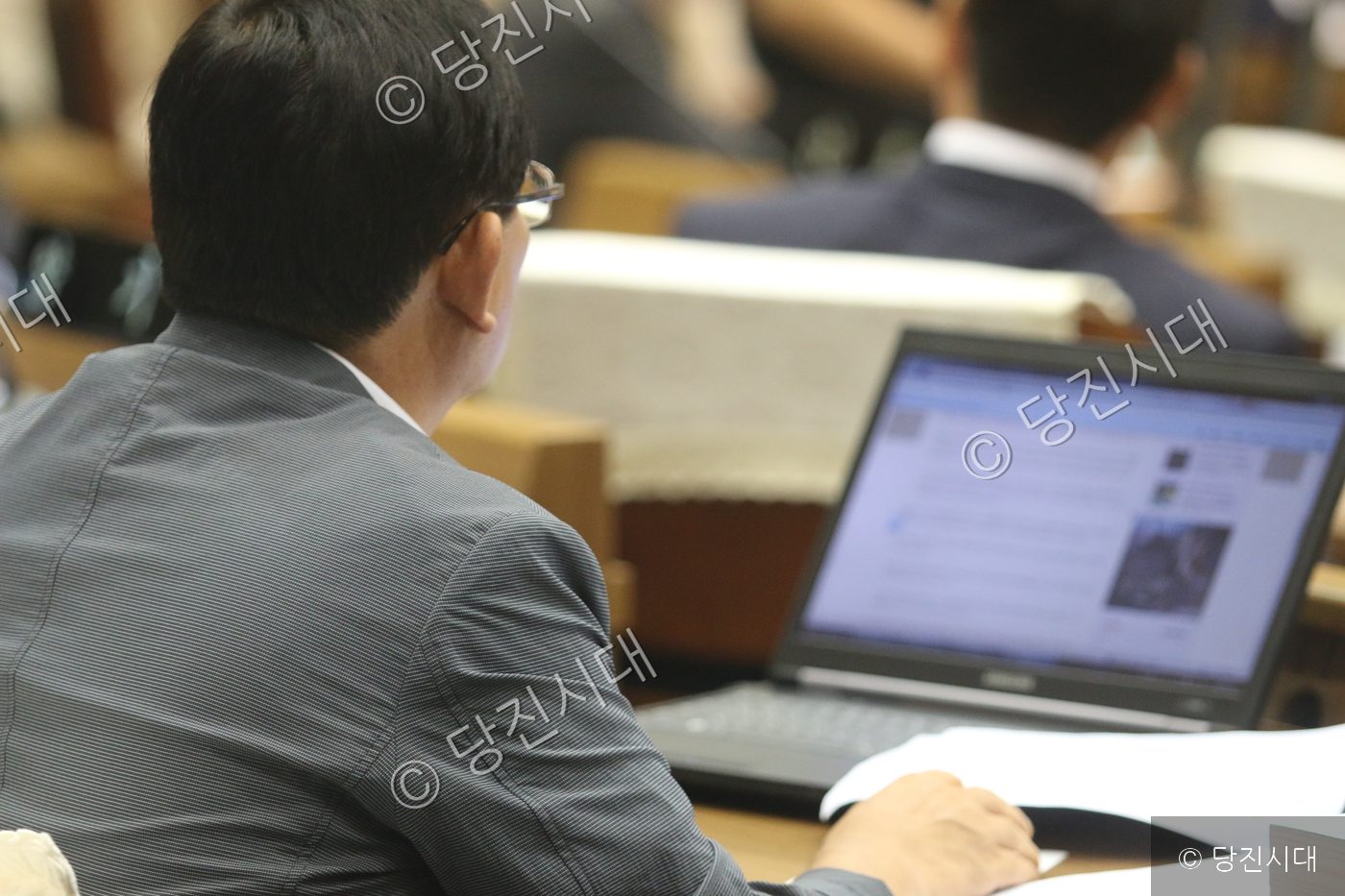 의회 회의장에서 한 의원이 노트북을 보며 시정질문을 준비하고 있다.