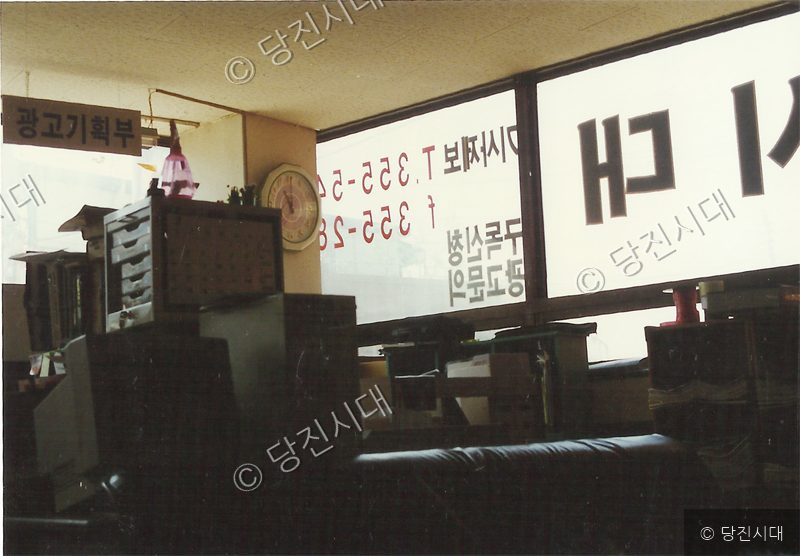어수선한 실내에 사무 집기와 가구 등이 배치되어 있다.