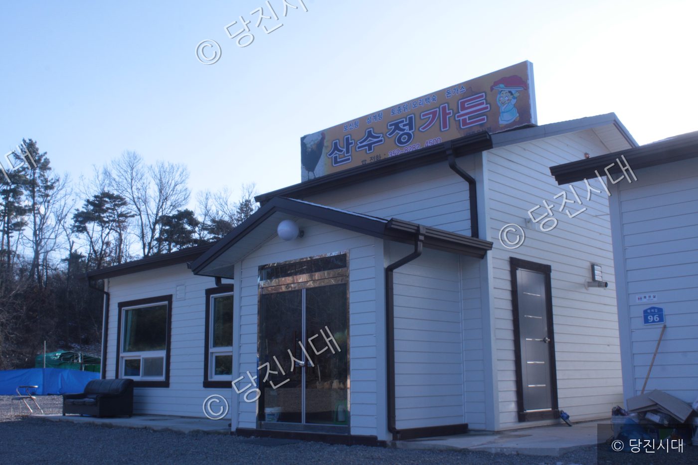 하얀색 외벽과 식당 간판이 붙어 있는 단층 건물의 모습이다.
