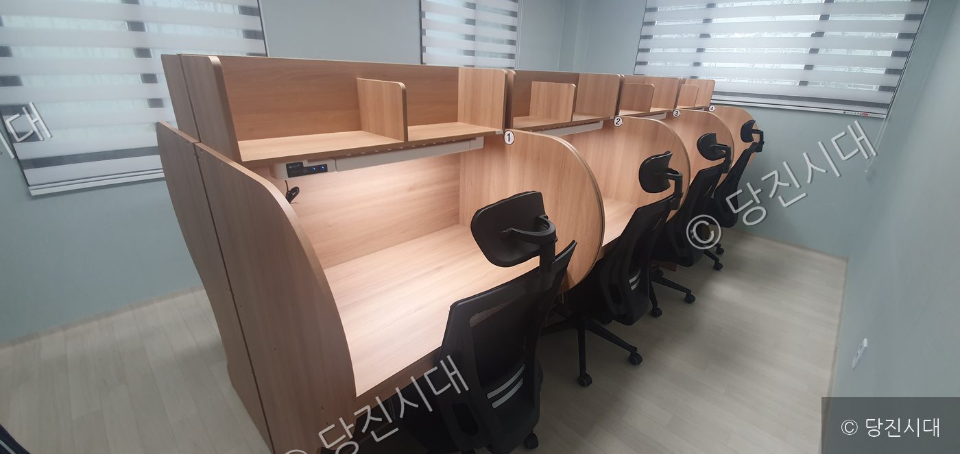 아파트 단지 내 스터디룸에 개인 독서실 책상들이 줄지어 놓여 있다.