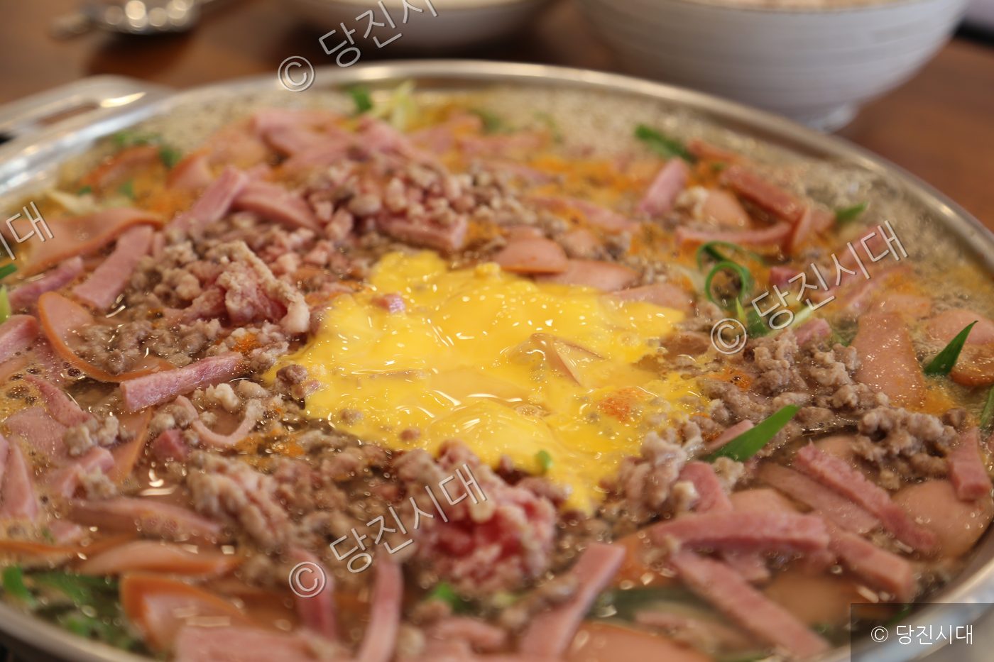 햄과 소시지, 다진 고기 등이 푸짐하게 담긴 부대찌개가 끓고 있다.