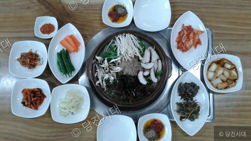 흑염소 요리와 다양한 밑반찬이 상에 차려져 있다.