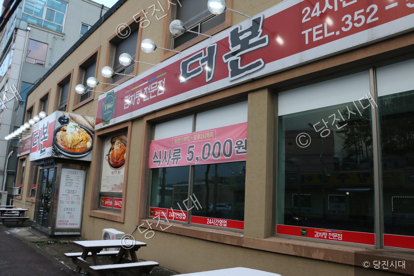 눈이 쌓인 거리에 식당 건물의 외관이 보인다.